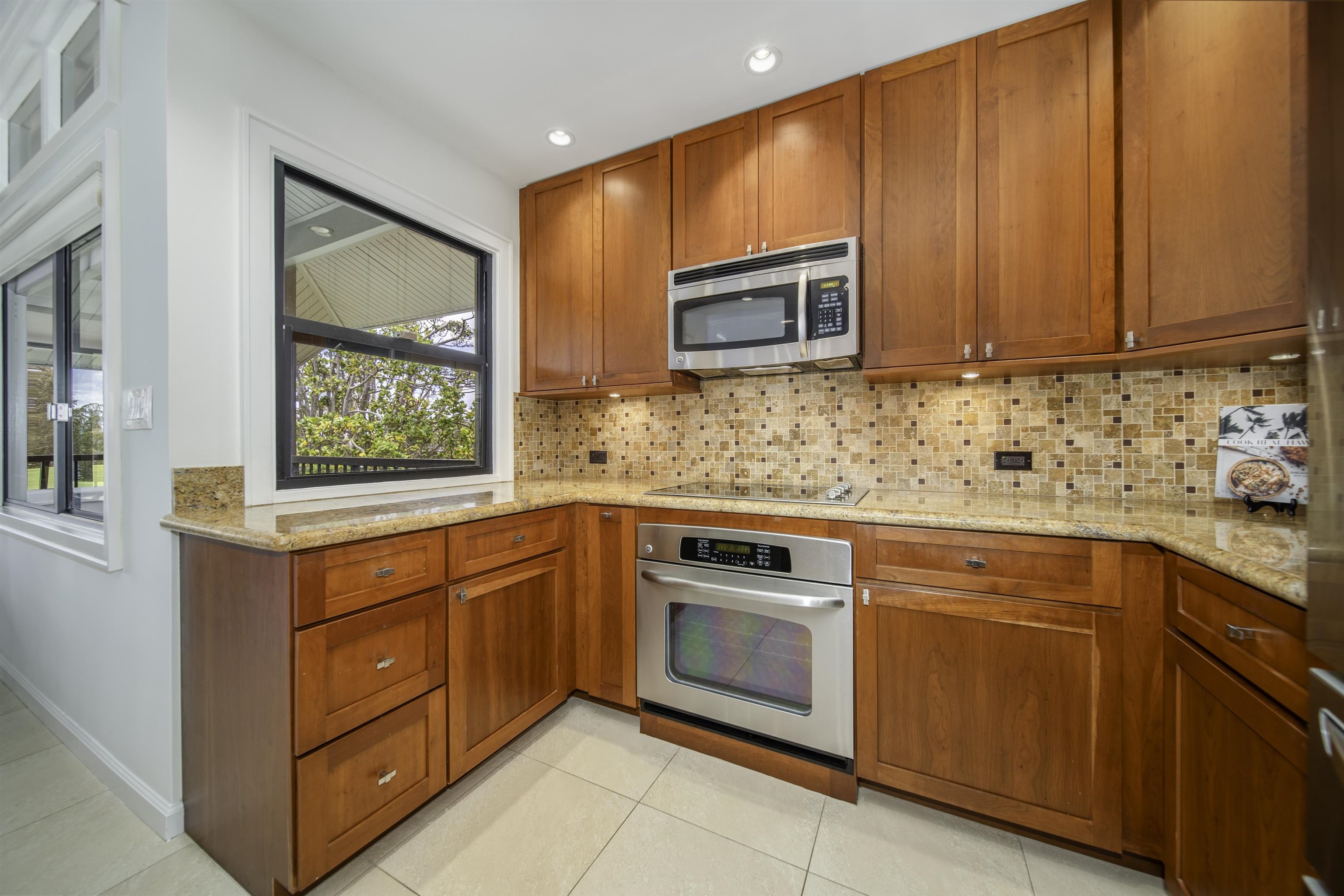 100 Ridge Road, Unit 232324 Lahaina, HI 96761 - Photo 8 of 50 a kitchen with stainless steel appliances granite countertop wooden cabinets a stove top oven with a sink and dishwasher