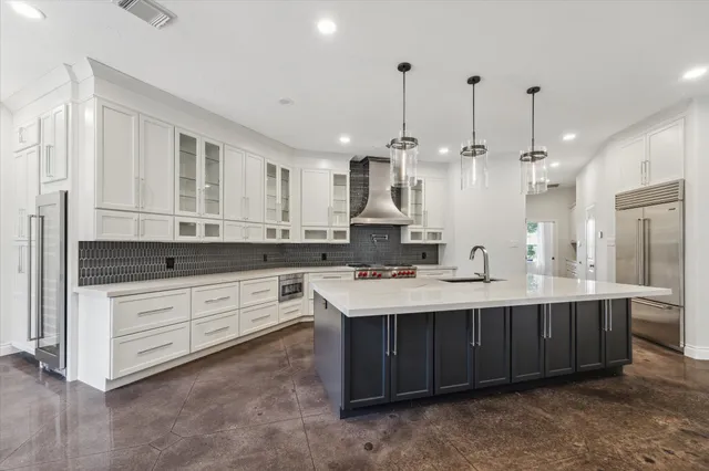 a kitchen with kitchen island a sink stainless steel appliances and cabinets