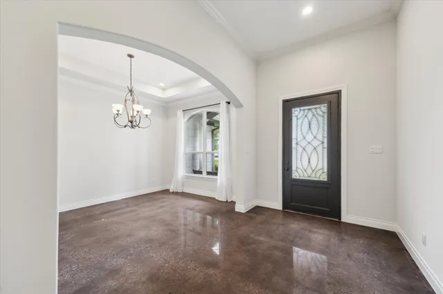 an empty room with windows and mirror