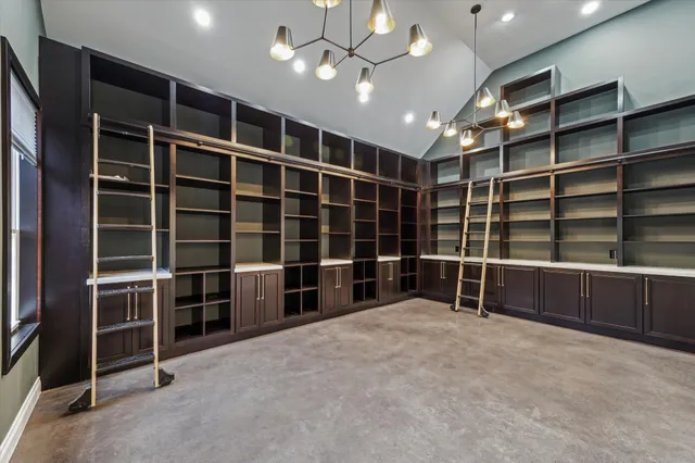 a view of an empty room with furniture and window