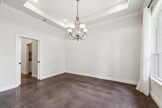 a view of a room with a chandelier fan and windows