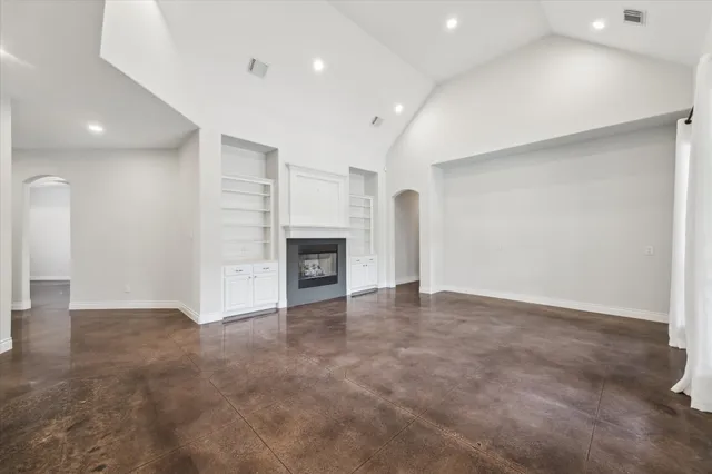 an empty room with fireplace and windows