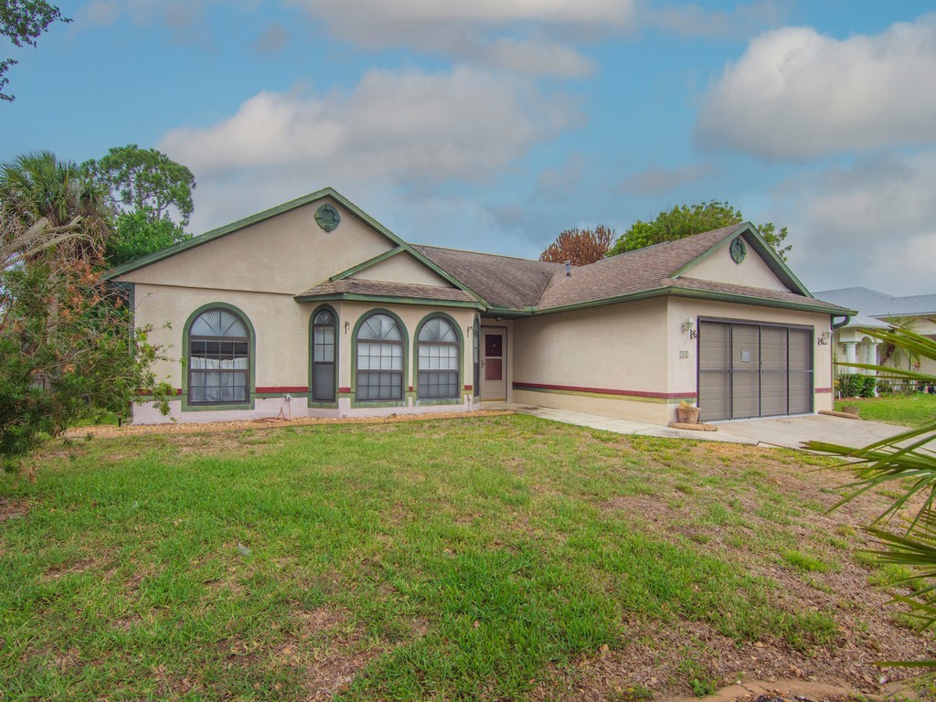 a front view of a house with a garden and yard