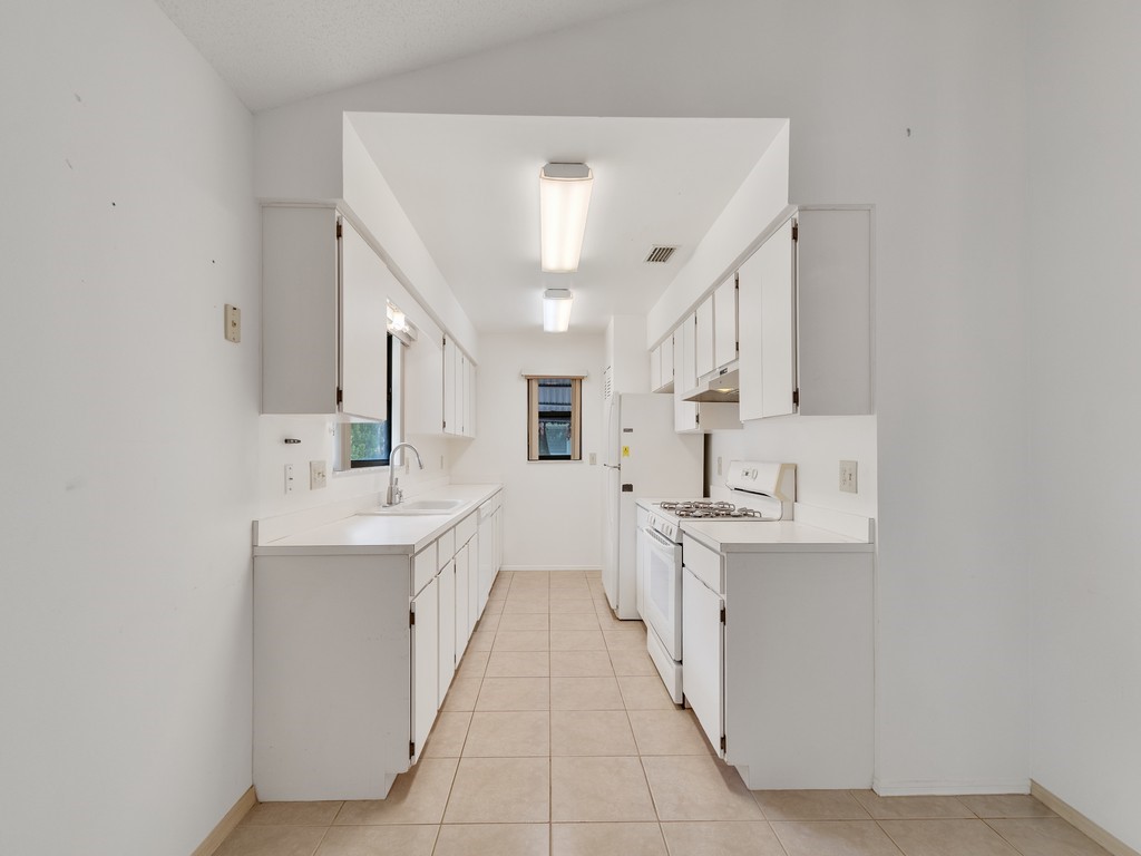 717 Doctor Avenue Sebastian, FL 32958 - Photo 15 of 33 a large white kitchen with cabinets and wooden floor