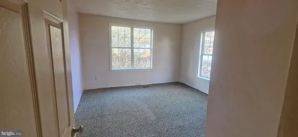 an empty room with windows and closet