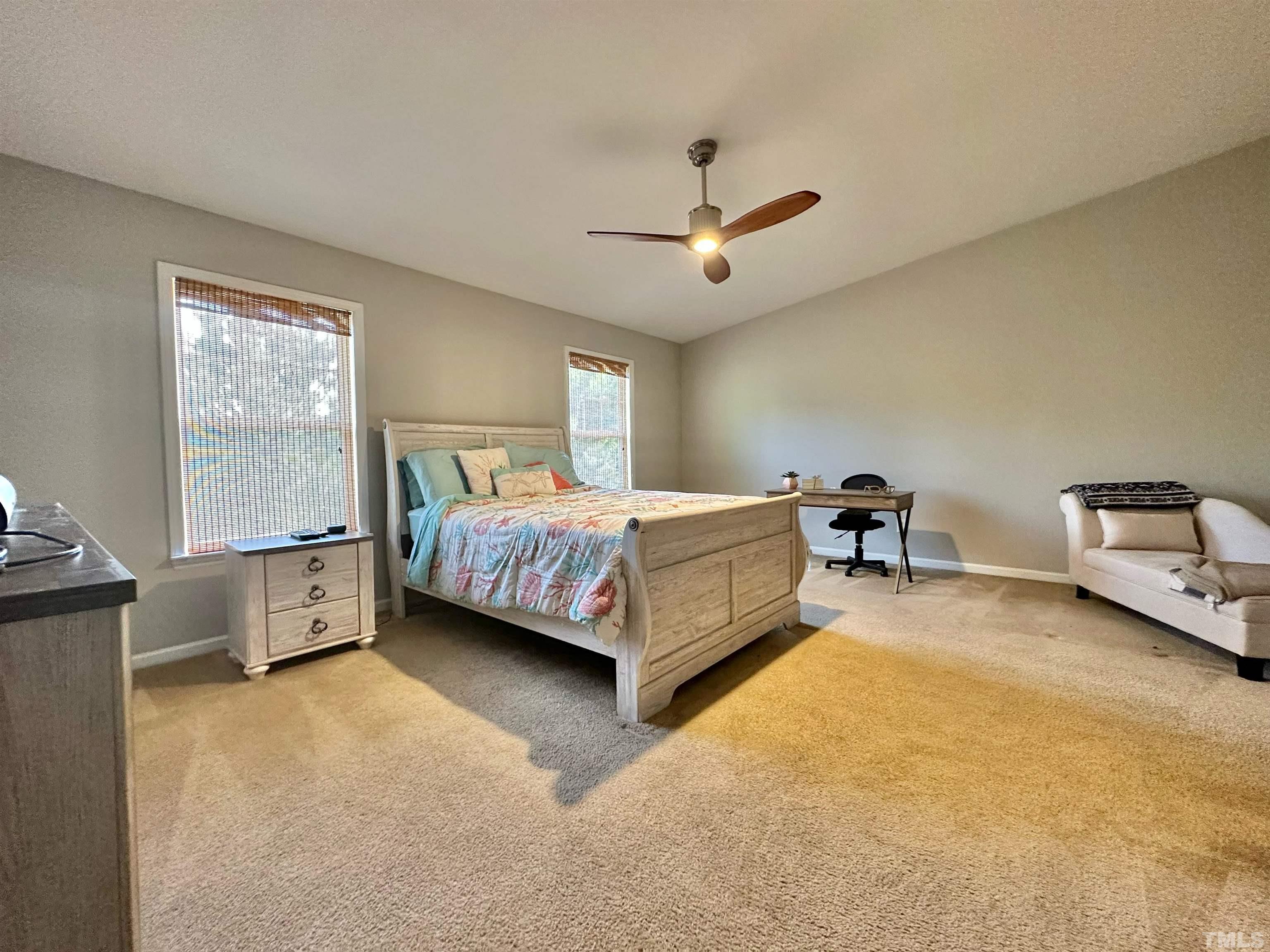330 Gilman Lane, Unit 110 Raleigh, NC 27610 - Photo 12 of 13 a spacious bedroom with a bed and a chandelier