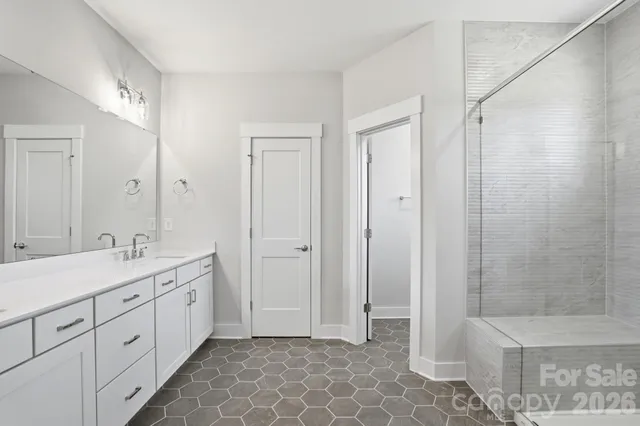 a spacious bathroom with a double vanity sink a toilet and a shower