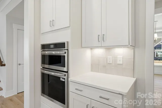 a kitchen with white cabinets and stainless steel appliances