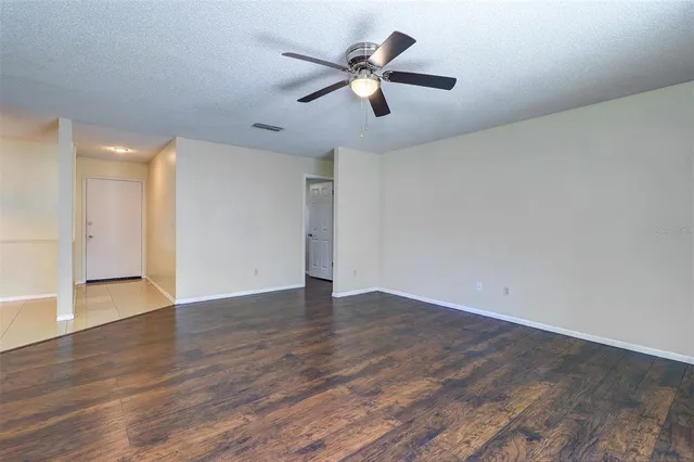 a view of an empty room with wooden floor