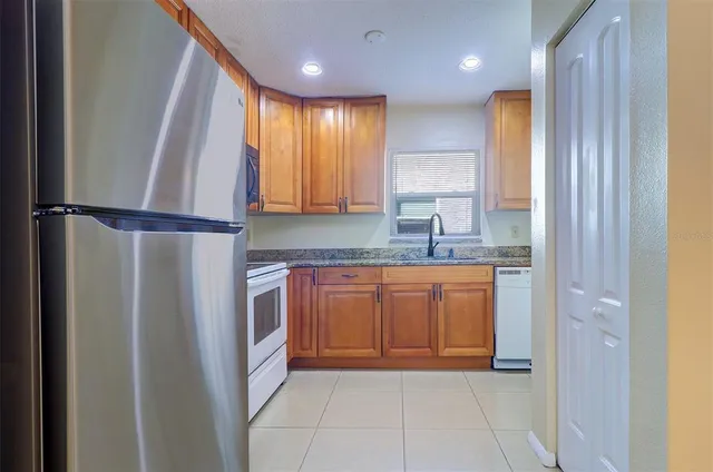 a kitchen with stainless steel appliances granite countertop a refrigerator and a sink