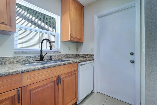 a kitchen with granite countertop white cabinets and sink