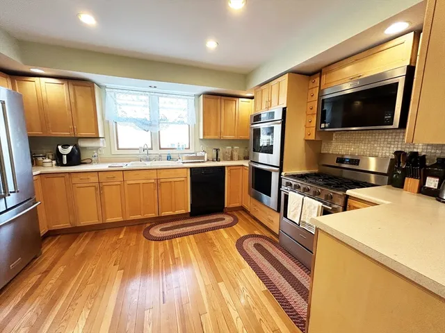 a kitchen with wooden floors appliances and cabinets