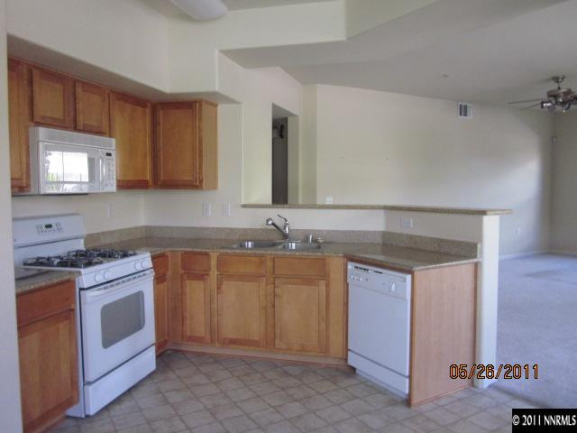 9050 Double R Boulevard, Unit 111 Reno, NV 89511 - Photo 4 of 8 a kitchen with stainless steel appliances granite countertop a sink stove and cabinets