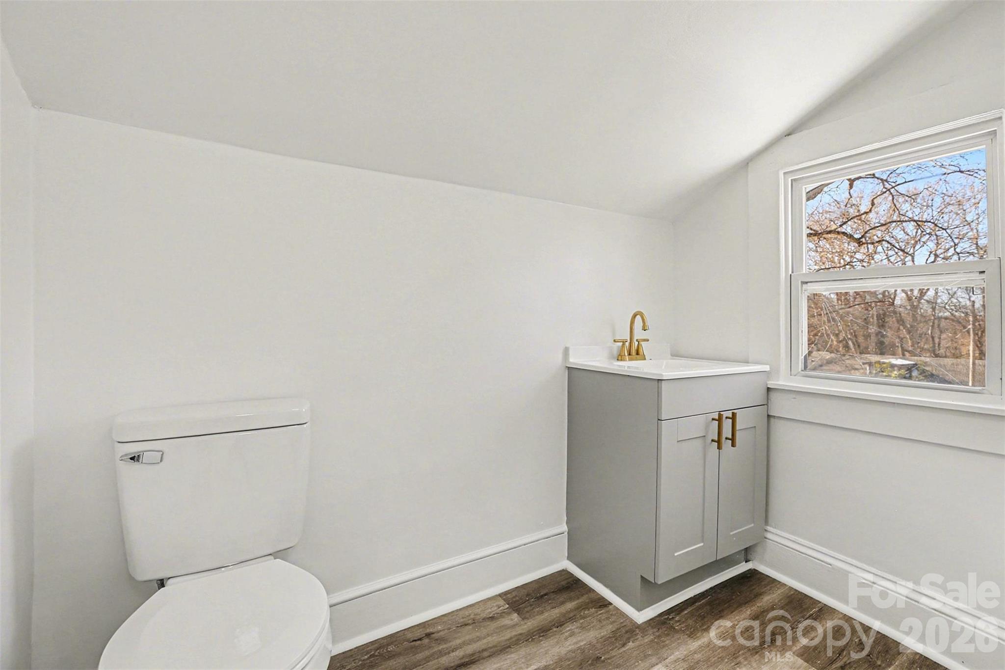 1013 Ridge Avenue Gastonia, NC 28052 - Photo 26 of 33 a bathroom with a toilet a sink a window and mirror
