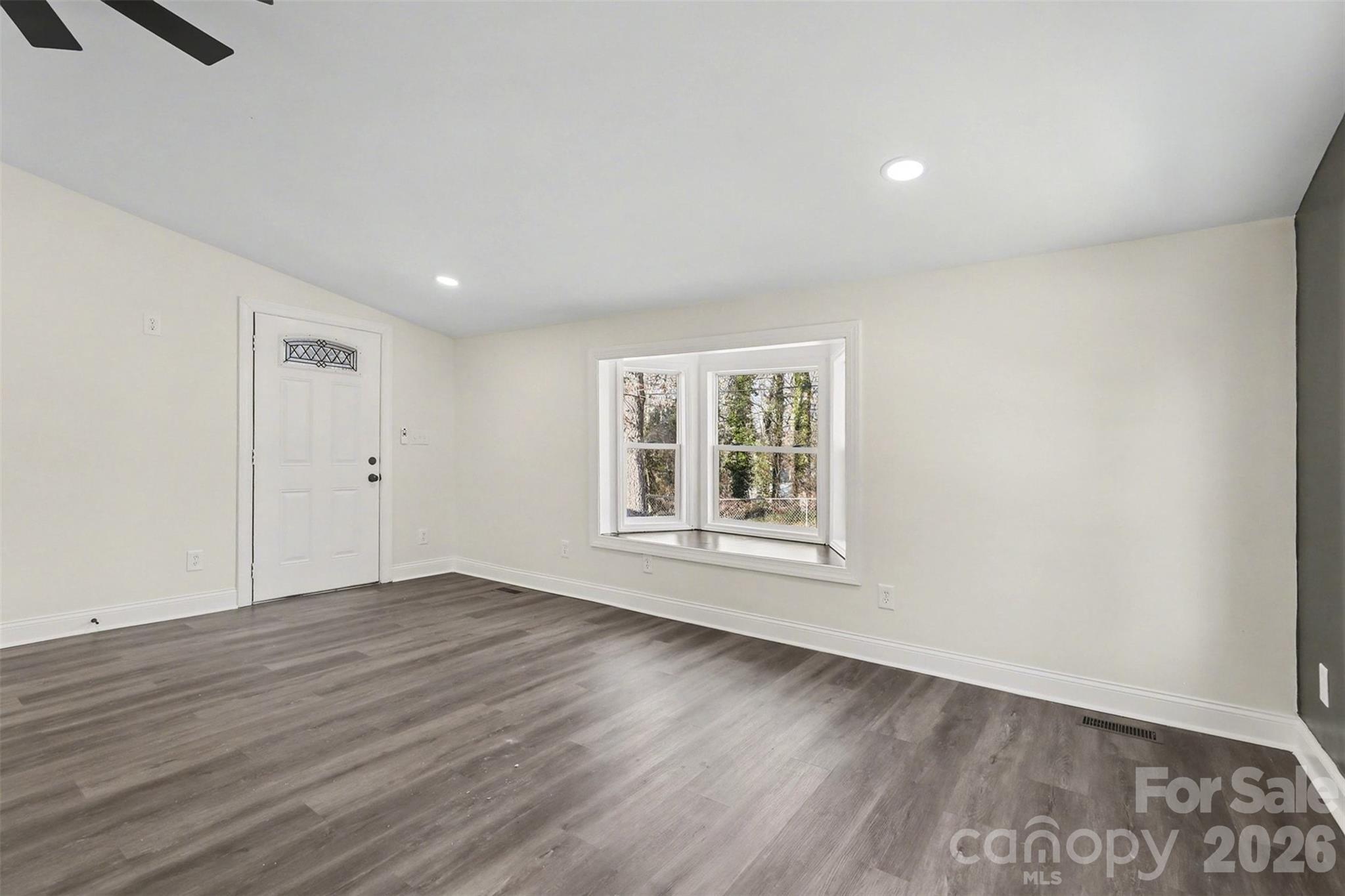 1013 Ridge Avenue Gastonia, NC 28052 - Photo 4 of 33 an empty room with wooden floor and windows