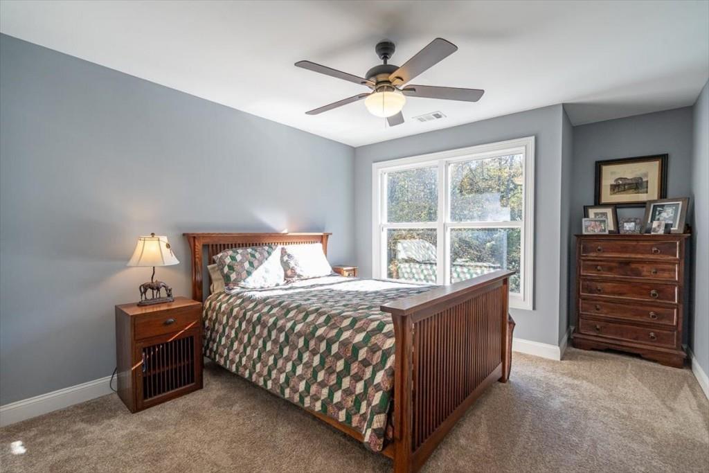 3055 Spring Hill Drive Monroe, GA 30656 - Photo 36 of 64 a bedroom with a bed and a chandelier