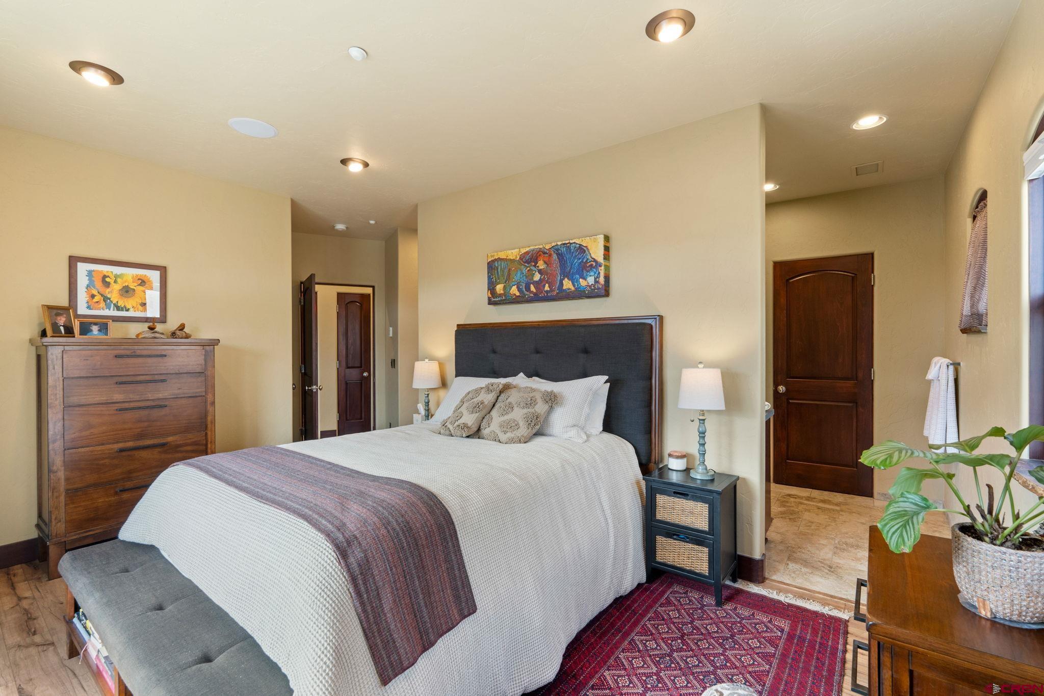 3416 Main Avenue, Unit 203 Durango, CO 81301 - Photo 17 of 34 a spacious bedroom with a bed a dresser and potted plant on the dresser