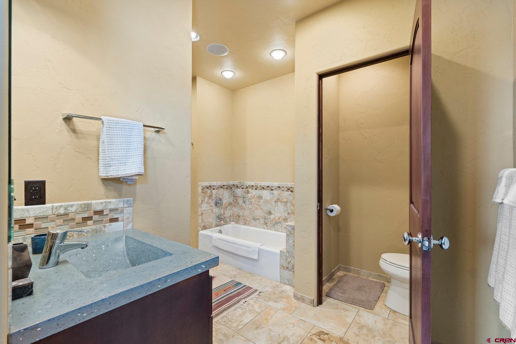 3416 Main Avenue, Unit 203 Durango, CO 81301 - Photo 20 of 34 a bathroom with a granite countertop sink a toilet and shower
