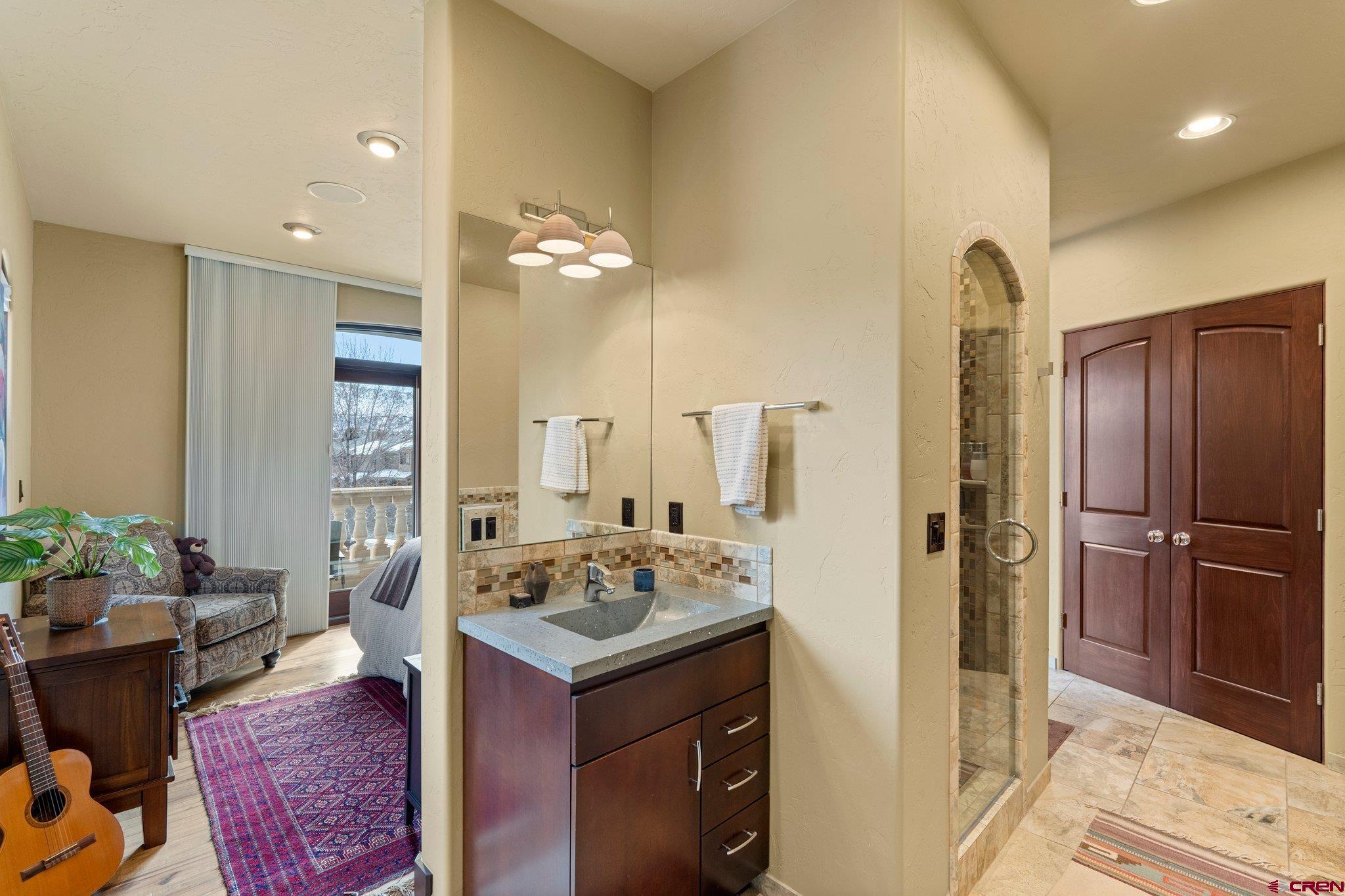 3416 Main Avenue, Unit 203 Durango, CO 81301 - Photo 21 of 34 a spacious bathroom with a granite countertop sink a mirror and shower