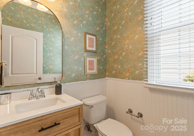 a bathroom with a granite countertop sink mirror vanity and toilet