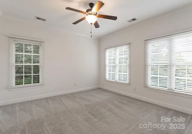 a view of an empty room with a window and a ceiling fan