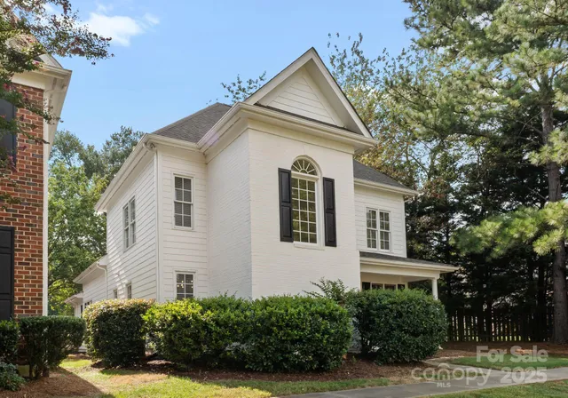 a view of house that has a tree in front of it