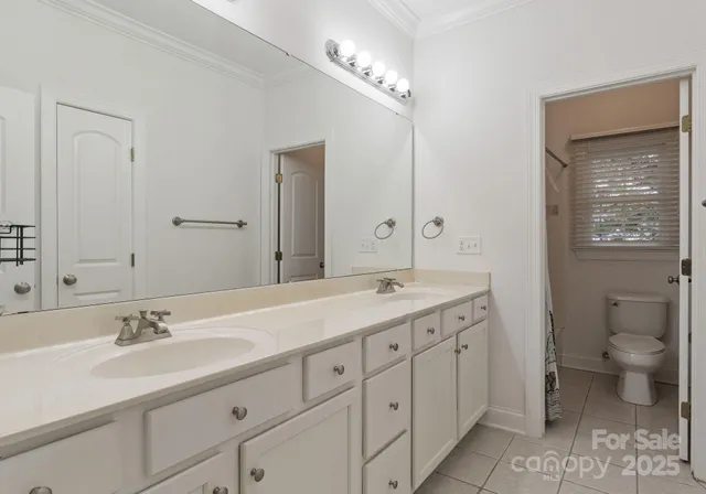 a spacious bathroom with a double vanity sink toilet and a mirror