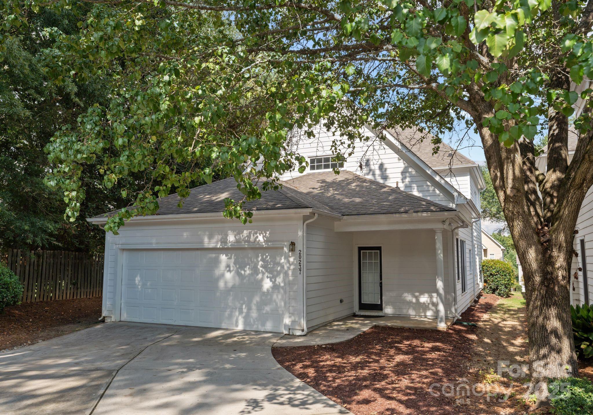 20237 Harroway Drive Cornelius, NC 28031 - Photo 4 of 23 a view of a house with a tree and wooden fence