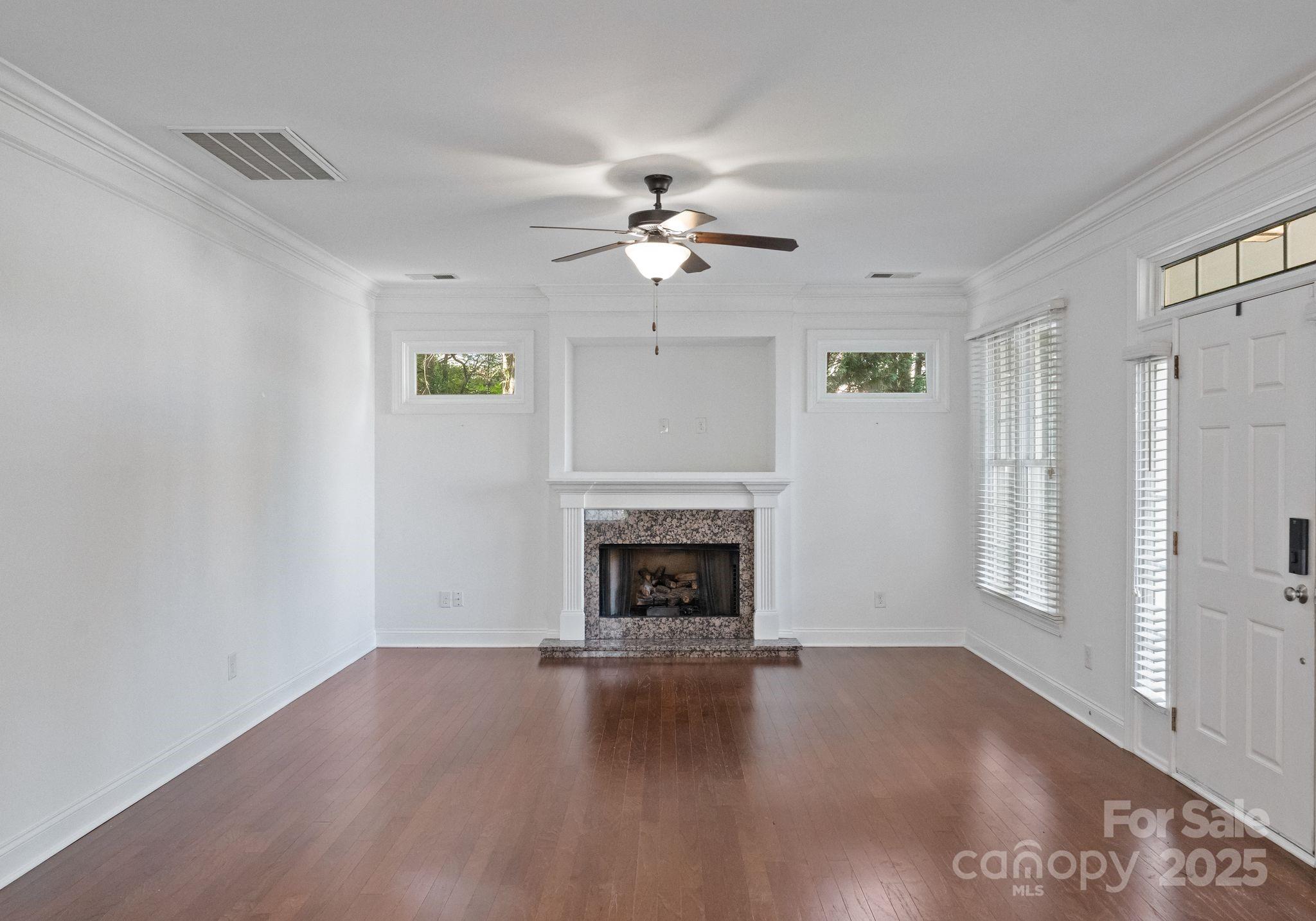 20237 Harroway Drive Cornelius, NC 28031 - Photo 5 of 23 a view of a livingroom with a fireplace a ceiling fan and windows