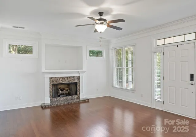 an empty room with windows and fireplace