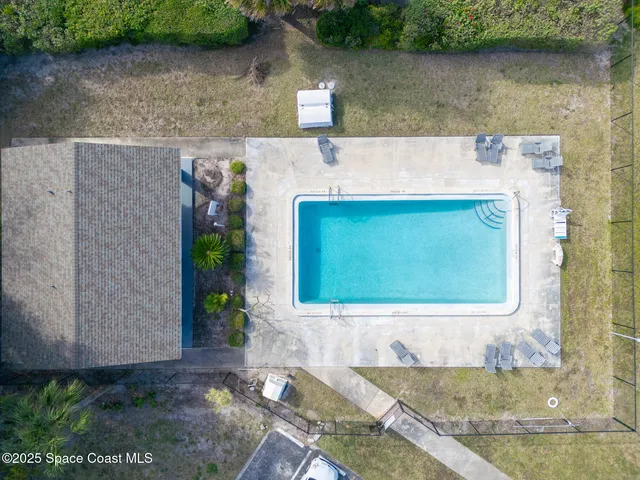 a backyard of a house with potted plants and brick wall