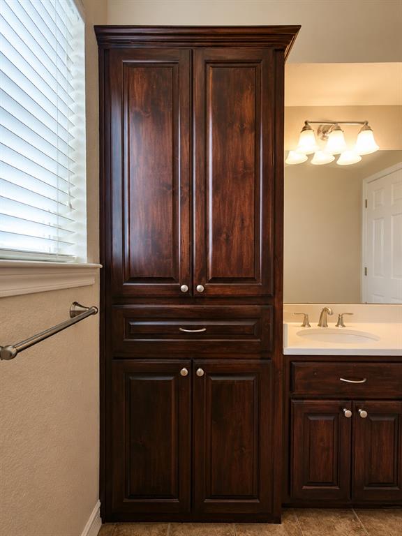 14752 Ranch Road Forney, TX 75126 - Photo 32 of 40 Full second bathroom- all, dark wood-finish cabinetry featuring multiple storage compartments-This photo was taken before family moved in