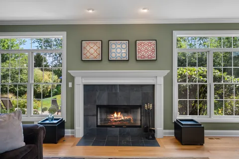 a living room with furniture a large window and a fireplace