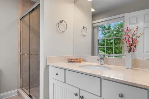 a bathroom with a granite countertop sink mirror and window