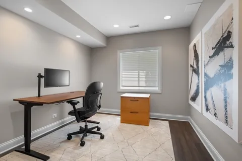 a view of a workspace with furniture and a window