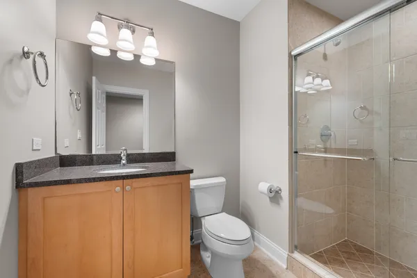 a bathroom with a granite countertop sink toilet and shower
