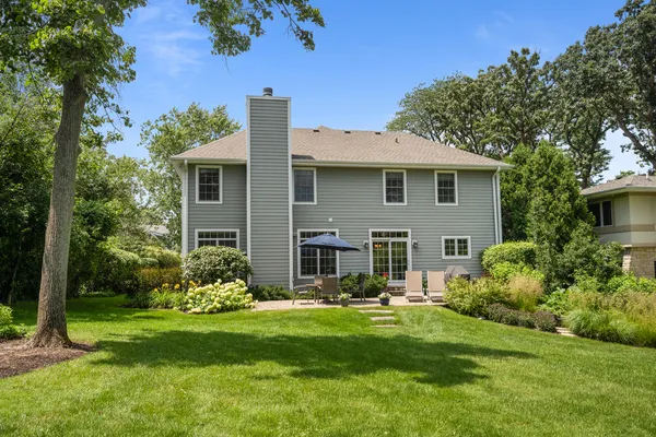 a front view of a house with a yard tree and outdoor seating