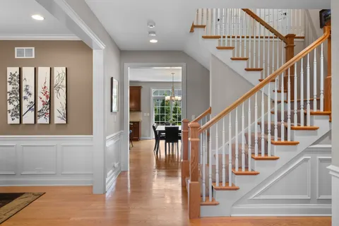 a view of staircase with lots of frames on wall and windows