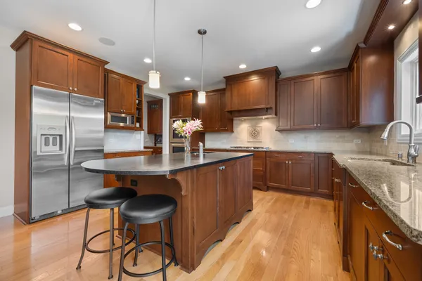a kitchen with stainless steel appliances granite countertop a sink refrigerator and cabinets