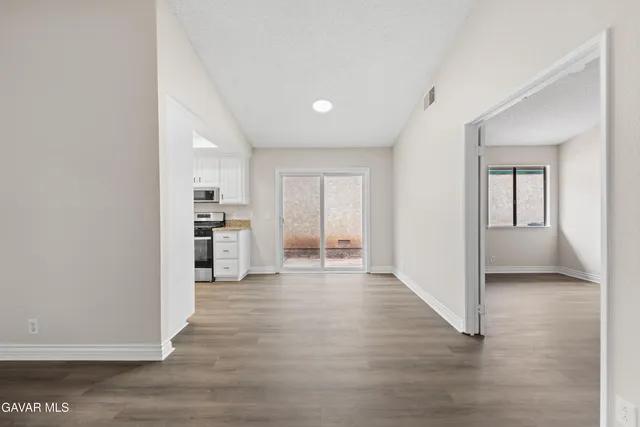 a view of a kitchen with wooden floor and a refrigerator