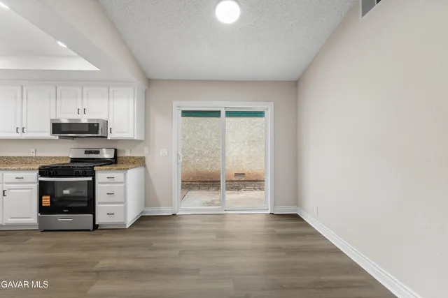 a kitchen with wooden floors and white appliances
