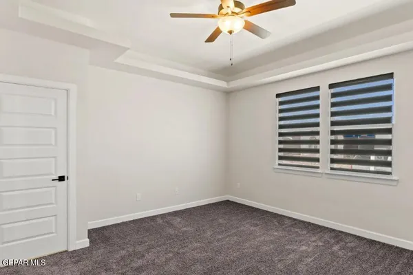 an empty room with a window and a fan