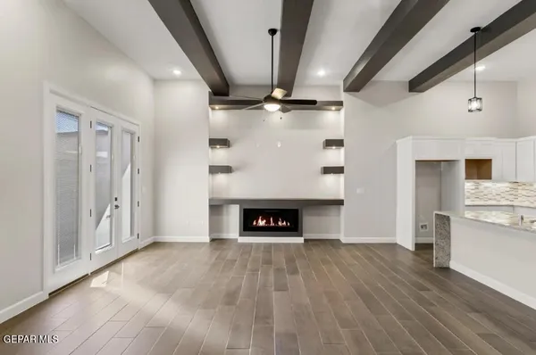 a view of an empty room with a fireplace and a window