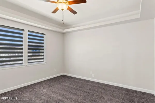 an empty room with a window and a fan