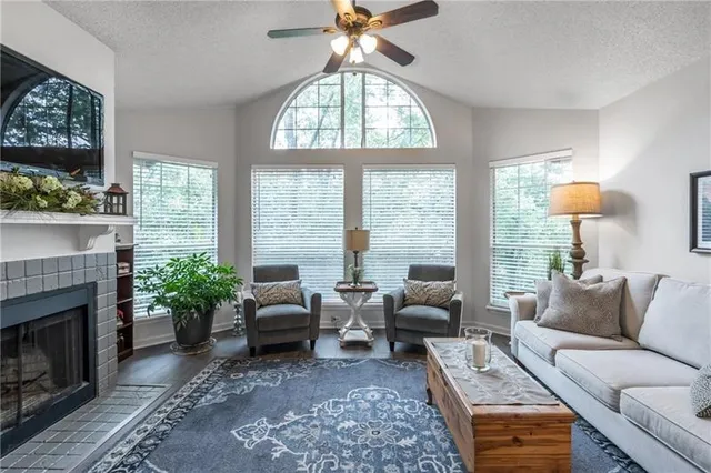 a living room with furniture a fireplace and a large window