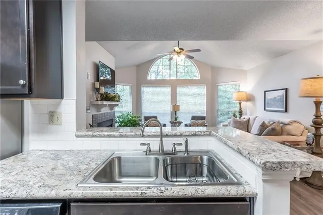 a kitchen with granite countertop a sink and a window