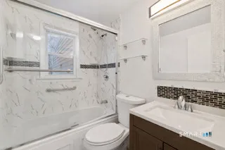 a bathroom with a sink a toilet and shower