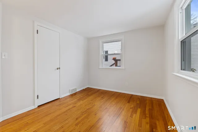 a view of empty room with wooden floor