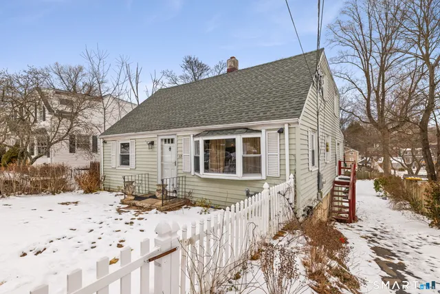 a front view of a house with a yard covered in snow