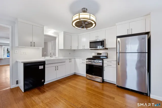a kitchen with a refrigerator and a stove top oven